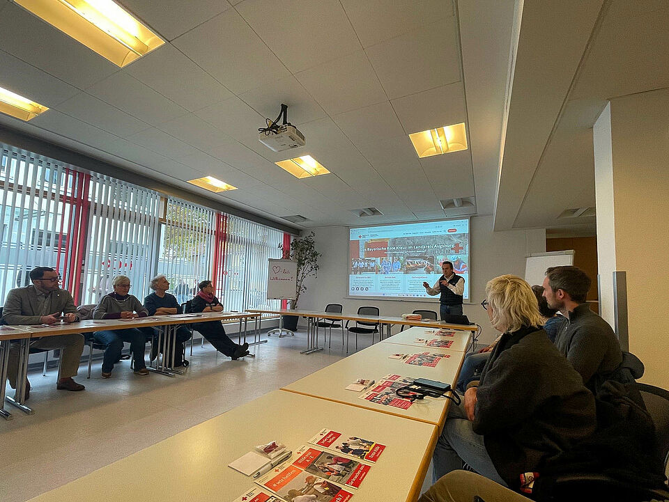 Blick in den Lehrsaal des BRK Augsburg-Land bei dem Besuch der Armutskonferenz. KGF Thomas Haugg bei seinem Vortrag.